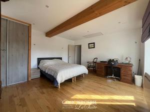a bedroom with a bed and a desk in it at La croix Luce in Cherbourg en Cotentin