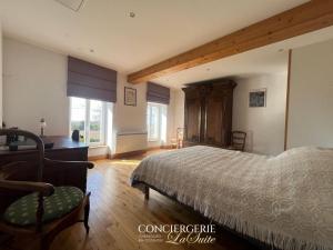 a bedroom with a bed and a desk and window at La croix Luce in Cherbourg en Cotentin