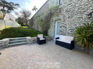 a patio with two chairs and a building at La croix Luce in Cherbourg en Cotentin