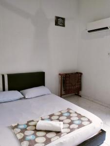 a bedroom with a bed with a rug on it at Penarik baru homestay in Penarek