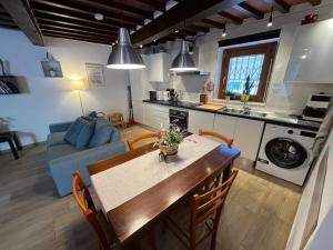 a kitchen and living room with a table and a couch at San Clemente House in Arezzo