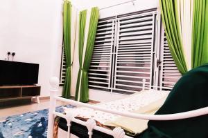 a bedroom with a bed and a window with green curtains at Ddiana Alor Setar Wifi 4 Airconds in Alor Setar