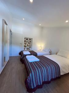 two beds in a room with white walls and wood floors at Casanova Country Villa in Santo António das Areias +14 photos