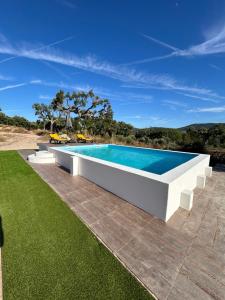 a swimming pool in the middle of a lawn at Casanova Country Villa in Santo António das Areias
