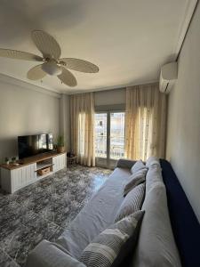 salon z kanapą i wentylatorem sufitowym w obiekcie A 1 MINUTO DE LA PLAYA Alojamiento 2 habitaciones - Aire Acc y ascensor w mieście Playa de Gandia