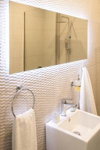 a white bathroom with a sink and a mirror at Pezodromos Apartments in Filiatra