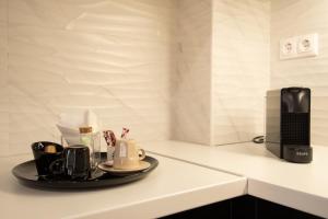 a counter with a tray of coffee cups and a microwave at Pezodromos Apartments in Filiatra