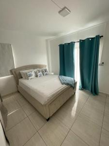 a bedroom with a bed with a green curtain at VILLA cHELSEA 2 bed room in Grand Gaube