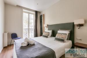 a bedroom with a large bed with a green headboard at 60-LUXURY PARISIAN HOME SEBASTOPOL (2DG) in Paris