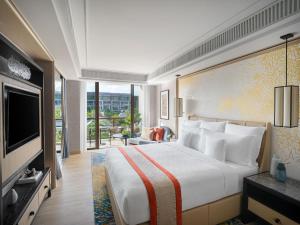 a hotel room with a large bed and a television at InterContinental Phuket Resort by IHG in Kamala Beach
