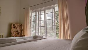 a bedroom with a bed and a large window at Trattorias Holiday Home in Varkala
