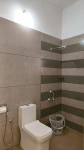 a bathroom with a white toilet in a room at Trattorias Holiday Home in Varkala