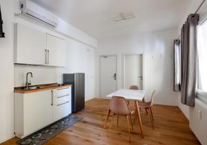 a kitchen with a table and chairs and a refrigerator at Fully Furnished Pink Apartment 2 in Treviso