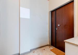 a room with a wooden door and a white wall at Fully Furnished Pink Apartment 2 in Treviso