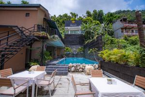 a hotel with a swimming pool and tables and chairs at Pokhara Boutique Hotel in Pokhara