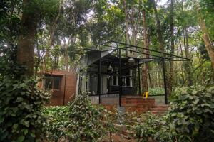a house in the middle of a forest at Cove by Raho - Nestled Away Retreat in Siddapur