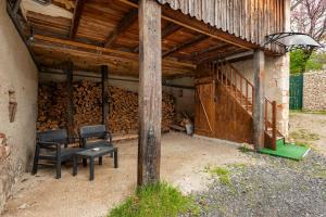 a room with two chairs and a pile of wood at Grange Caliana in La Vineuse