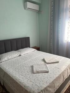 a bedroom with a bed with two towels on it at Hotel Luli City Center in Durrës