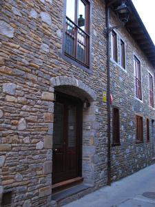 - un bâtiment en briques avec une porte en bois et une fenêtre dans l'établissement Peira Blanca Hotel Gastronómico, à Garós