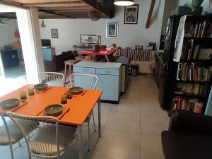 a dining room with an orange table and chairs at appartement de charme in Bessan