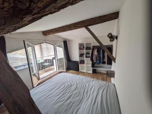 a bedroom with a bed and a window at appartement de charme in Bessan