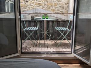 a patio with two chairs and a table on a balcony at appartement de charme in Bessan