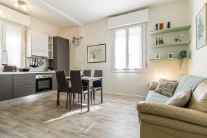 a kitchen and living room with a table and a couch at Cà MariLú in Castelfranco Emilia