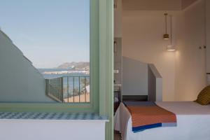 a bedroom with a bed and a view of the ocean at Mare Studios in Villajoyosa