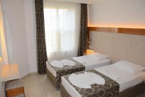 a hotel room with two beds and a window at Almera Park Apart Hotel in Alanya +33 photos