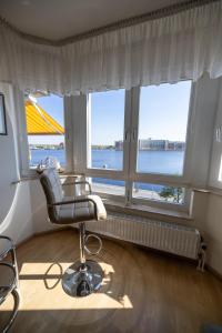 a room with a chair and a large window at Gemütliche Ferienwohnung mit Meerblick direkt am Hafen in Wilhelmshaven
