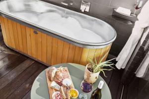 a bath tub with a table and a plate of food at Yellow Pots Apartment C, Luxurious Outdoor Bath in Wanaka +12 photos