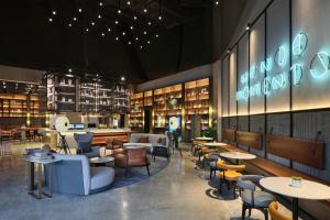 a restaurant with tables and chairs and a library at Wanda Moments Nanchang in Xinjian