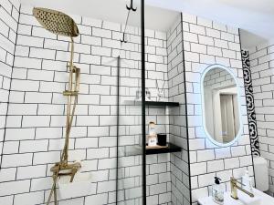 a white tiled bathroom with a shower and a sink at Central Spacious Apartment with Balcony - Alba Carolina in Alba Iulia +33 photos