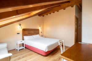 sypialnia z dużym białym łóżkiem i stołem w obiekcie Hotel Alda Lalín w mieście Lalín