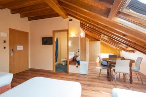 pokój z łóżkiem, stołem i krzesłami w obiekcie Hotel Alda Lalín w mieście Lalín