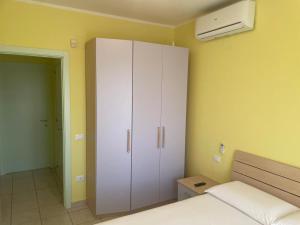 a bedroom with a white cabinet and a bed at Appartamento Luigi in Alba Adriatica