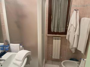 a bathroom with a sink and a toilet and towels at Appartamento Luigi in Alba Adriatica +15 photos