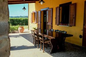 a wooden table and chairs in front of a building at B&B La Casa del Gallese in Sorbolongo