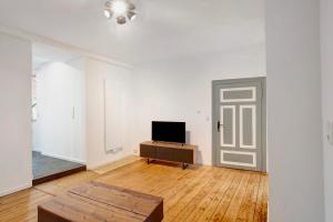 an empty white room with a tv and a door at Ferienwohnung Rheinschlendern in Rüdesheim am Rhein