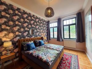 a bedroom with a bed with a floral wall at ArtHouse Bad Schandau in Bad Schandau