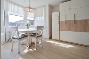 Un comedor con una mesa y sillas blancas. en FeWo Grytz, en Dahme