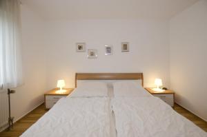 Un dormitorio con una cama grande con dos mesitas de noche. en FeWo Grytz, en Dahme