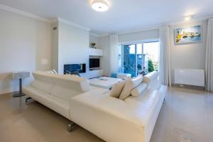 拉戈斯Boa Vista - Golf View Villa的客厅里有一张白色的沙发和一张桌子