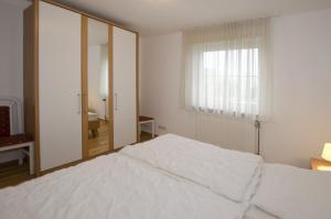 Un dormitorio con una cama blanca y una ventana. en FeWo Grytz, en Dahme