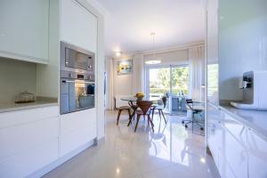 拉戈斯Boa Vista - Golf View Villa的厨房拥有白色的墙壁和桌椅