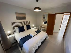 a bedroom with a large white bed with blue pillows at Central Apartment at Bismarck5 in Swakopmund +15 photos