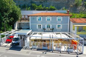 a blue building with a car parked in a parking lot at Blue Pearl Elite Apartments in Piran