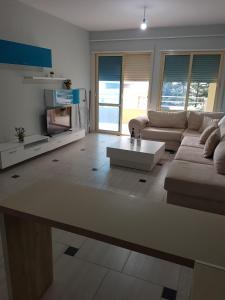 a living room with a couch and a coffee table at Blue Horizon Apartment in Sarandë +12 photos