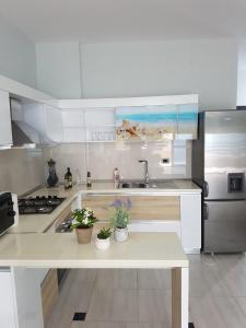 a white kitchen with a sink and a refrigerator at Blue Horizon Apartment in Sarandë