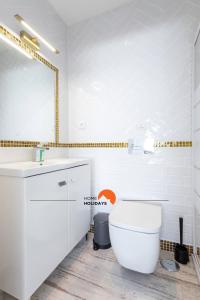 a white bathroom with a toilet and a sink at #078 Prestige Villa by Home Holidays in Páteo